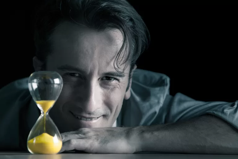 Portrait of Luca di Filippo, Creative Director, posing near by an hourglass